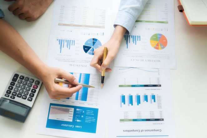 two business people looking at financial information with a calculator 