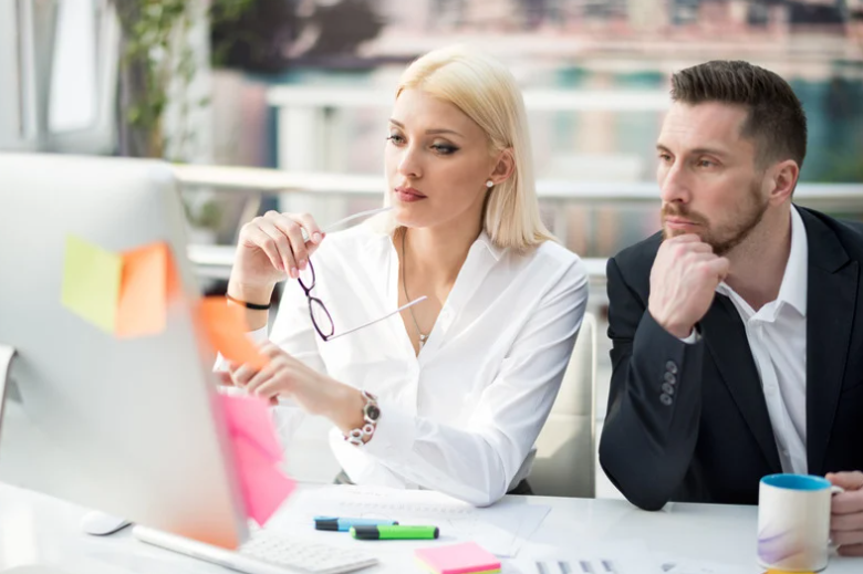 Business couple in the office looking at a computer screen