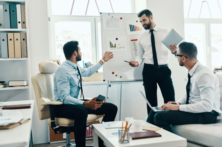 Young man in a suit conducting a business presentation using flipchart working in the office 