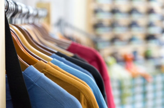row of colourful jumpers on a rack of a retails shop 